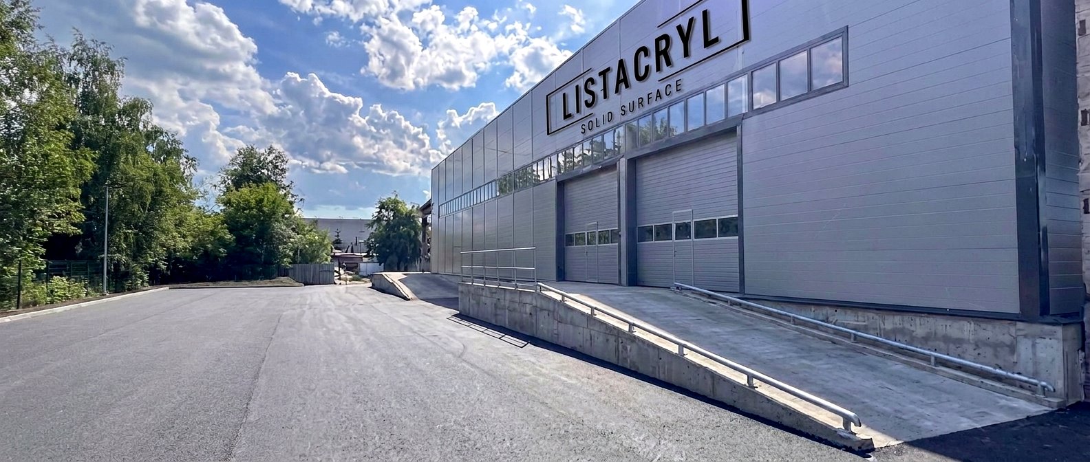 Производственный корпус LISTACRYL в Киришах — вывеска LISTACRYL SOLID SURFACE на фасаде, погрузочные ворота с пандусом